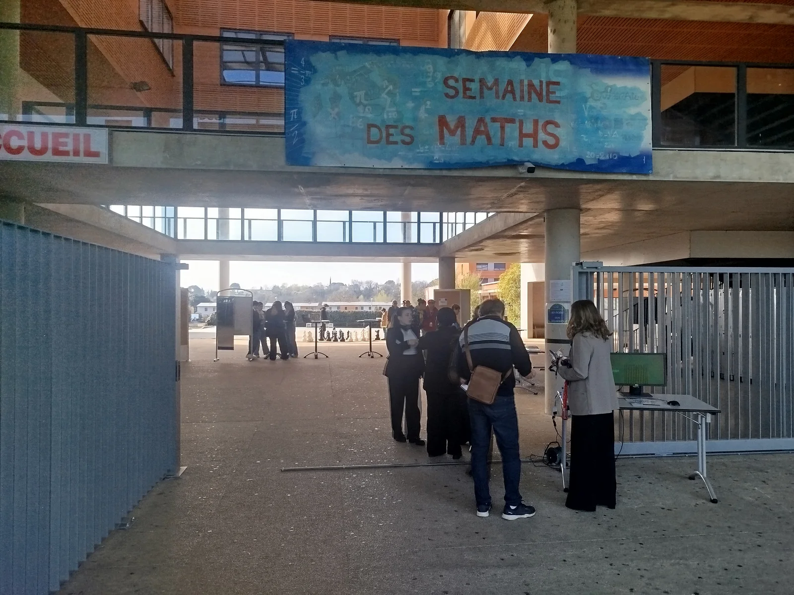 Des visiteurs à l’entrée du Salon, sous une banderole Semaine des maths.
